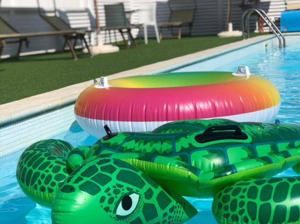 Piscine avec gonflables colorés, tortue et bouée.