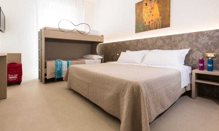 Gemütliches Zimmer mit Doppelbett und Etagenbetten, dekoriert mit einem Gemälde.