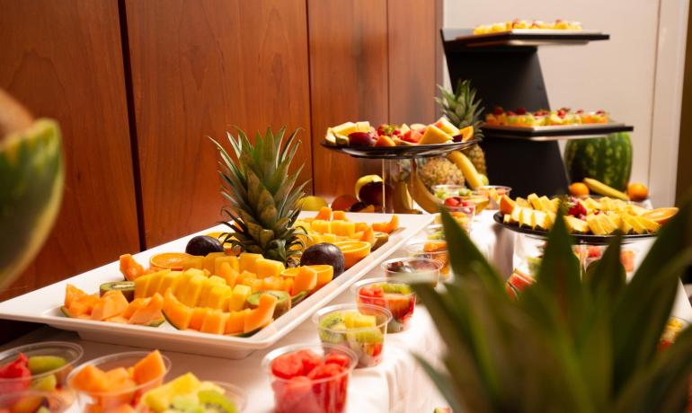 Fruit buffet with pineapple, oranges, and kiwi.