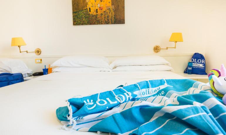 Camera d'albergo con letto matrimoniale e decorazioni colorate.