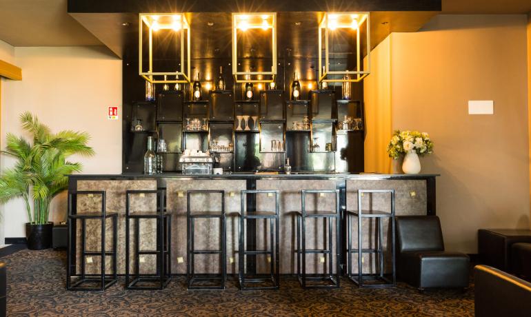 Elegante bar con sgabelli moderni e illuminazione sofisticata.