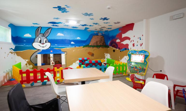 Aire de jeux pour enfants avec des décorations colorées et des jeux interactifs.