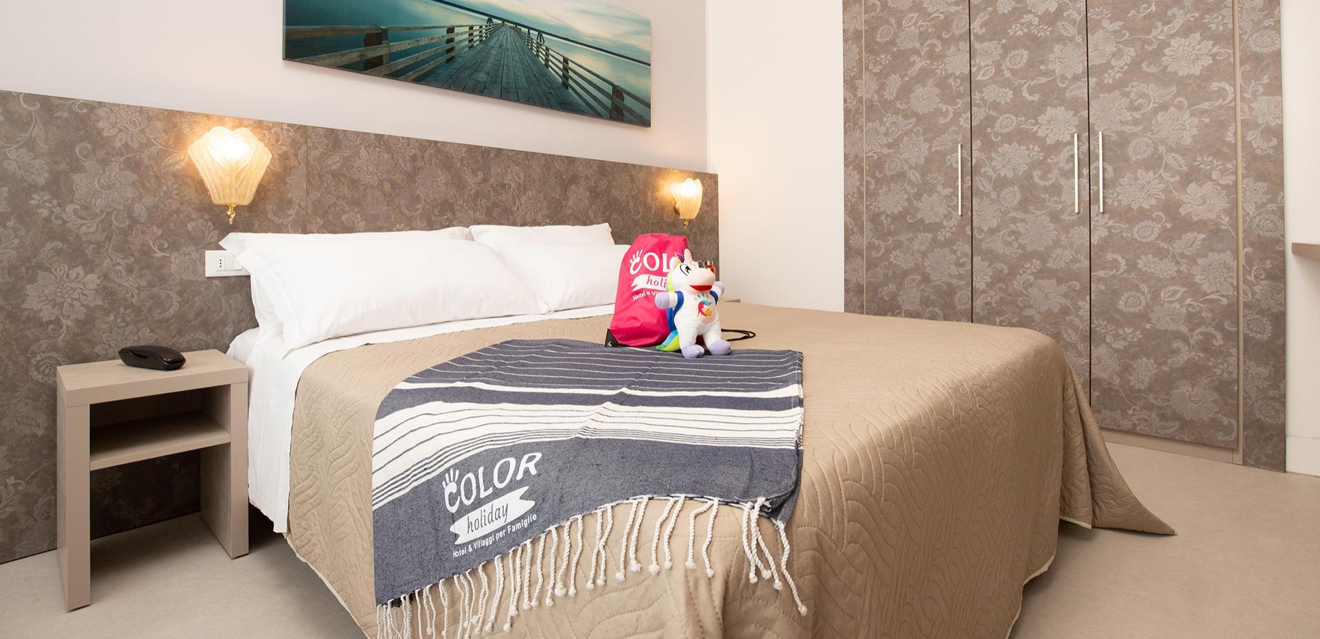 Famiglia felice in una stanza, bambina con peluche su letto a castello.