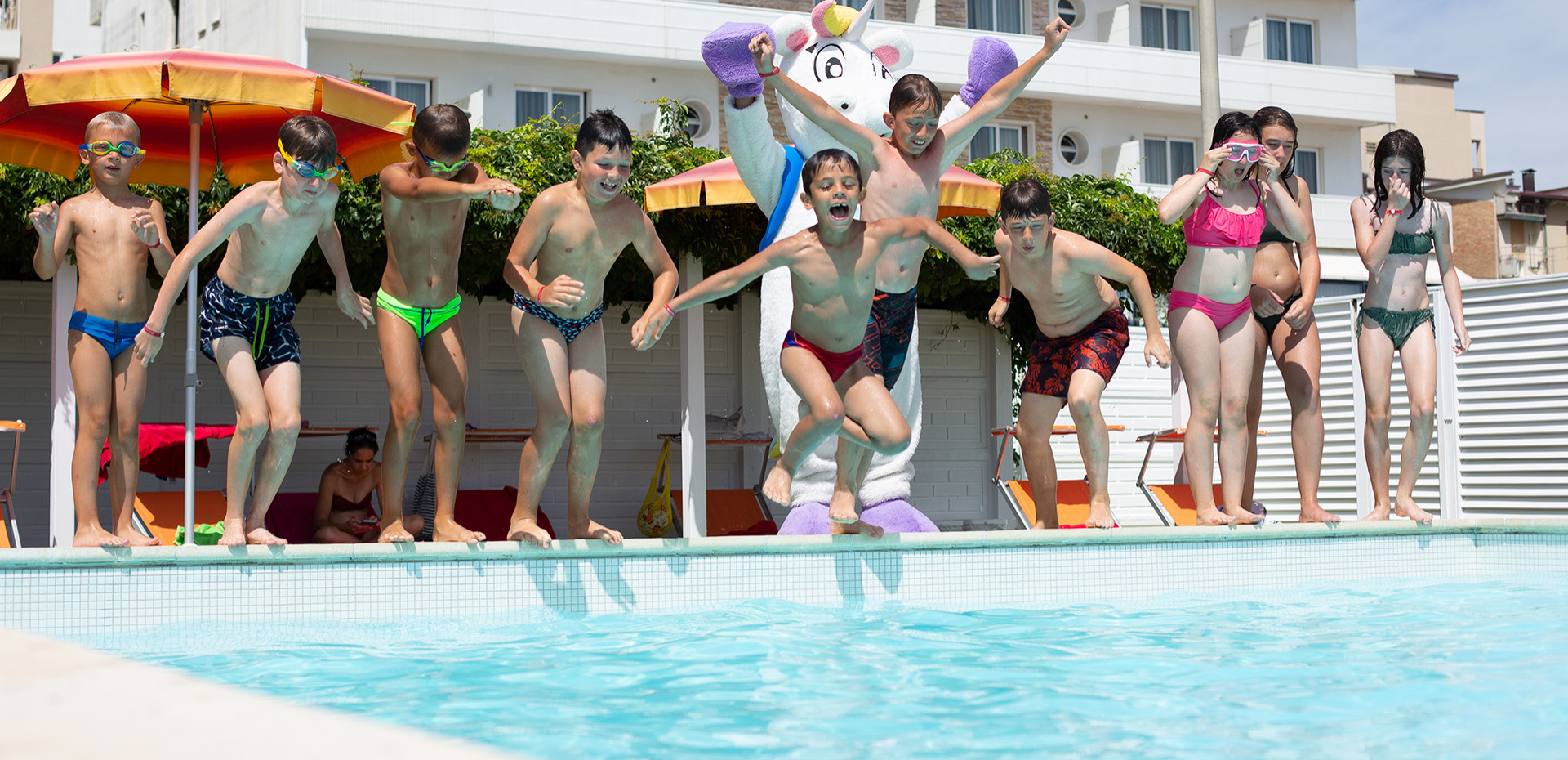 Piscina con giochi acquatici e gonfiabili colorati in un ambiente soleggiato.