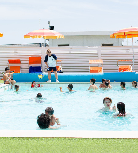 Lively pool with children playing and adults relaxing.
