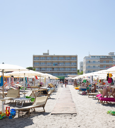 Crowded beach, colorful umbrellas, bright sun, lively and joyful summer.