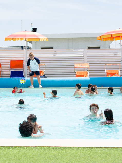 Lively pool with children playing and adults relaxing.