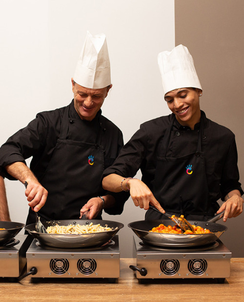 Buffet con piatti caldi e freddi, illuminato da lampade riscaldanti.