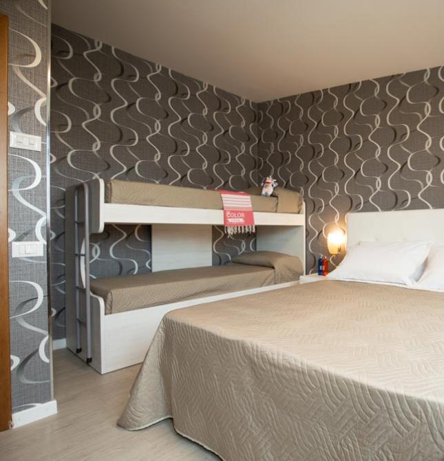 Cozy room with double bed and bunk beds, warm and modern atmosphere.
