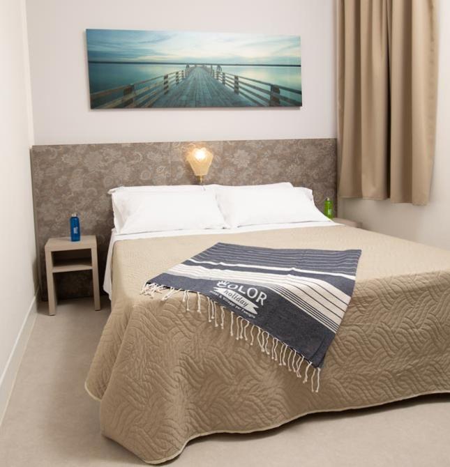 Cozy room with a double bed, beige blanket, and relaxing atmosphere.