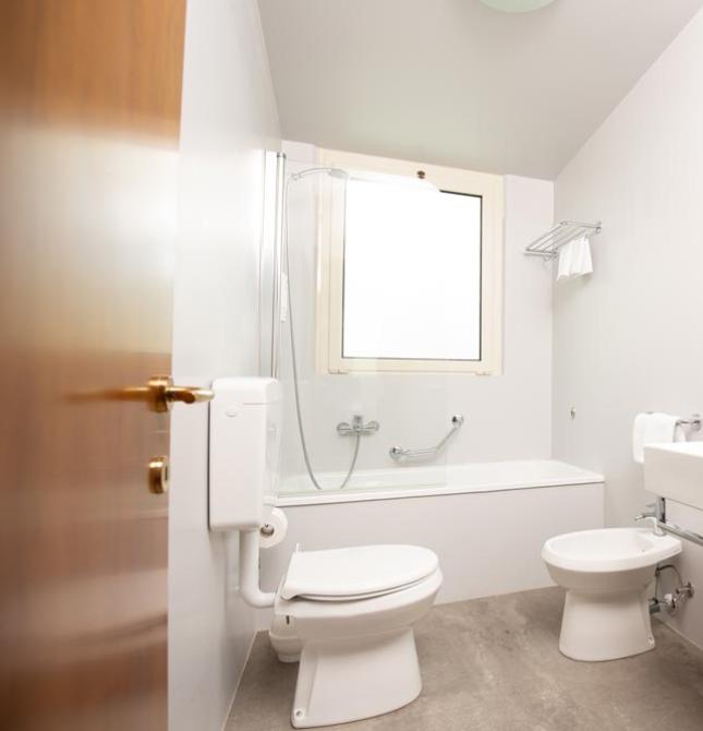 Modern, bright, and clean bathroom with a bathtub, sink, and colorful accessories.