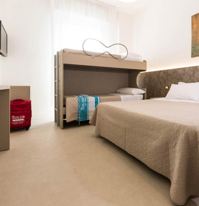 Bright room with double bed and bunk beds, adorned with vibrant art.