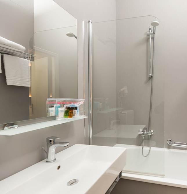 Modern, bright bathroom with tub and white towels, relaxing atmosphere.