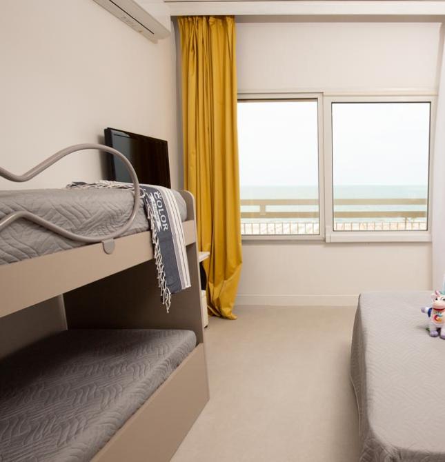 Bright room with sea view, cozy beds, and relaxing atmosphere.