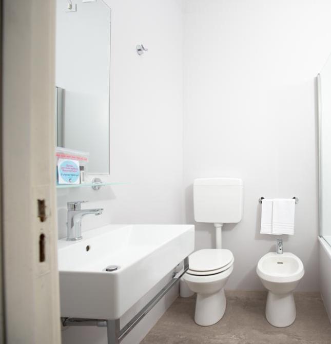 Bright, modern bathroom, minimalist and clean, with a white bathtub and fixtures.