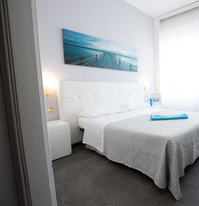 Bright, modern room with a double bed and bunk beds.