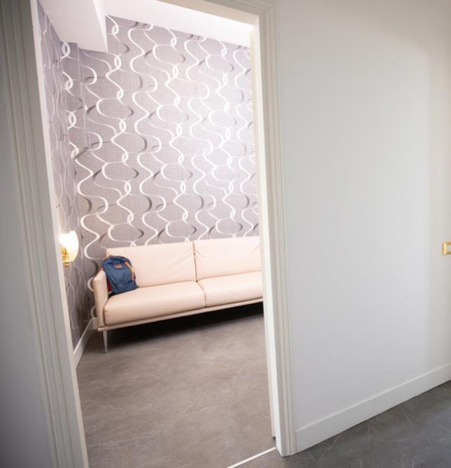 Bright entryway with beige sofa and elegant wallpaper.